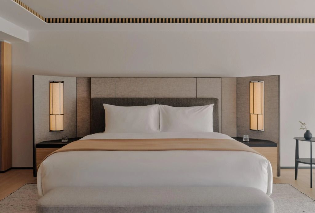 Bett im modernen Design mit stilvollen Lampen links und rechts