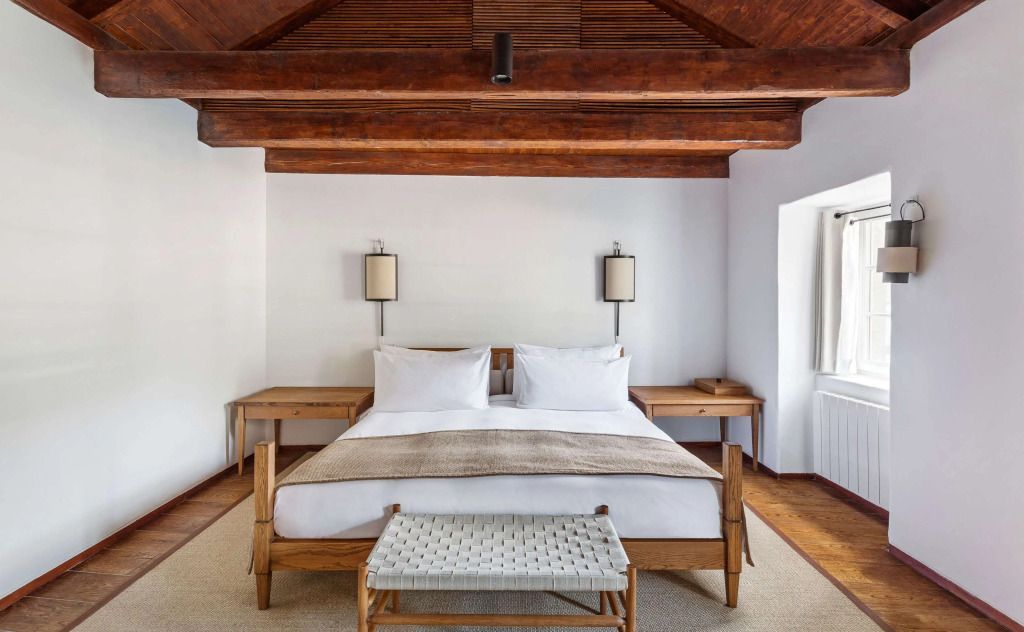 Schlafzimmer mit Holzbalkendecke und Doppelbett