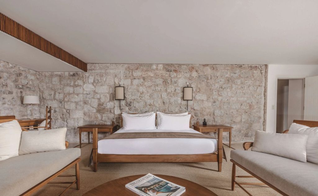 Elegantes Schlafzimmer mit Steinwand und modernen Möbeln im Hotel Aman Sveti Stefan