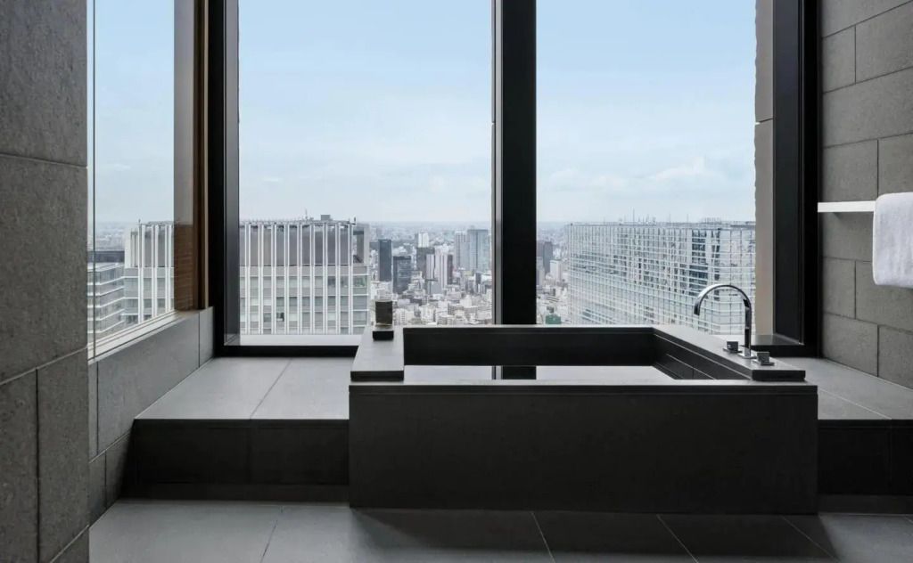 Luxuriöses Bad mit großer Badewanne und spektakulärem Blick auf die Stadt.