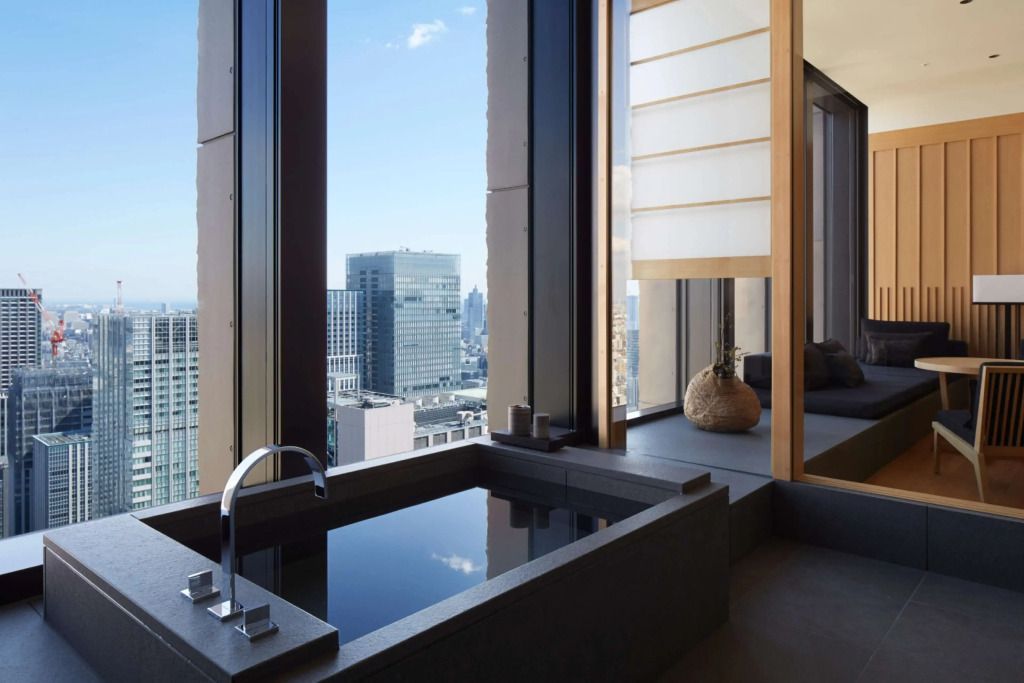 Luxuriöses Badezimmer mit freistehender Badewanne und Aussicht auf die Stadt