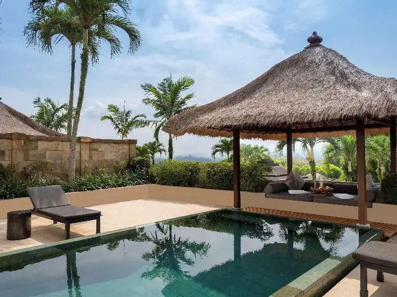 Privater Pool mit überdachtem Pavillon und üppigen Palmen im Hintergrund