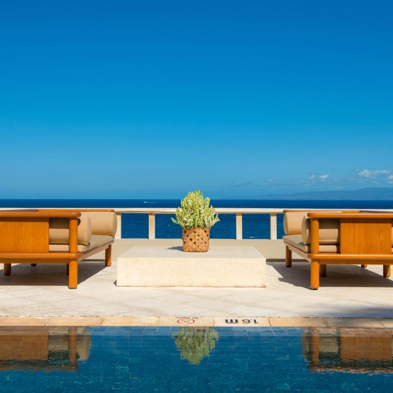 Terrasse mit bequemen Sitzmöbeln und Blick auf das Meer