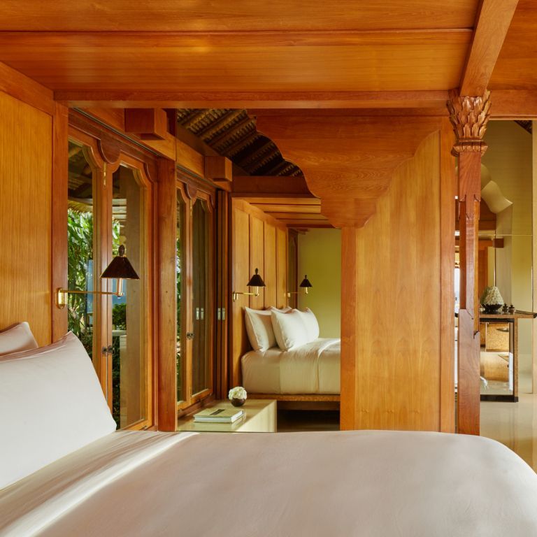 Luxuriöses Schlafzimmer mit Holzakzenten und großem Doppelbett in der Indrakila Suite