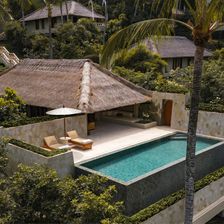 Infinity Pool in tropischer Umgebung mit Sonnenliegen und Schirm