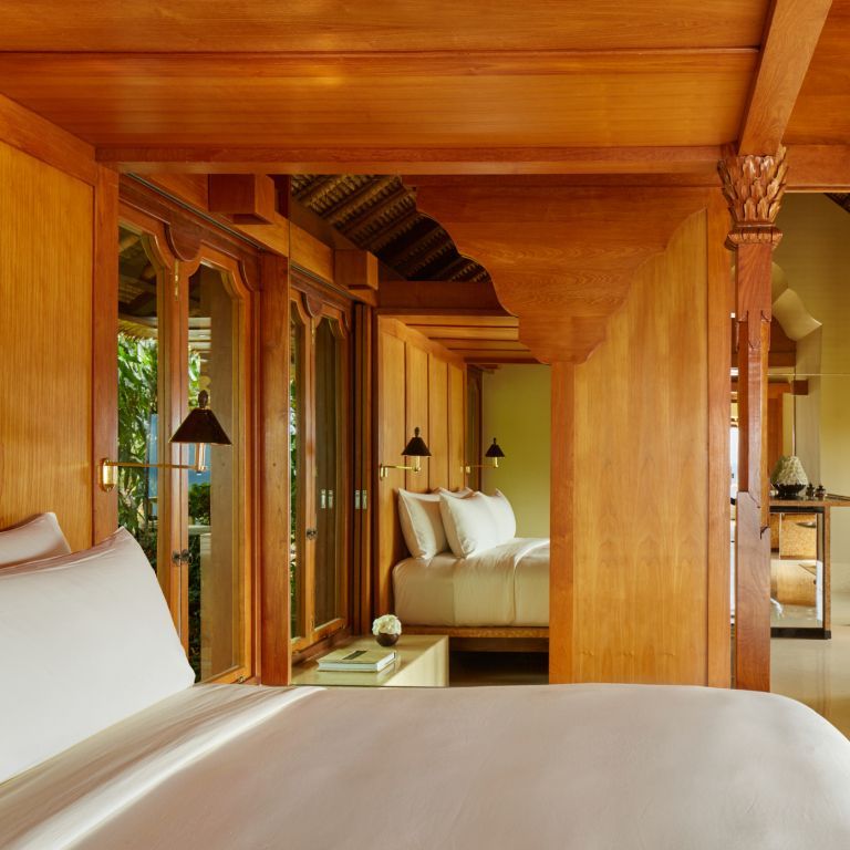 Luxuriöses Doppelzimmer mit Holzverkleidung und großem Fenster im Amankila Hotel