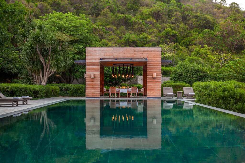 Luxuriöser Pool mit Blick auf üppige grüne Landschaft und elegante Sitzgelegenheiten