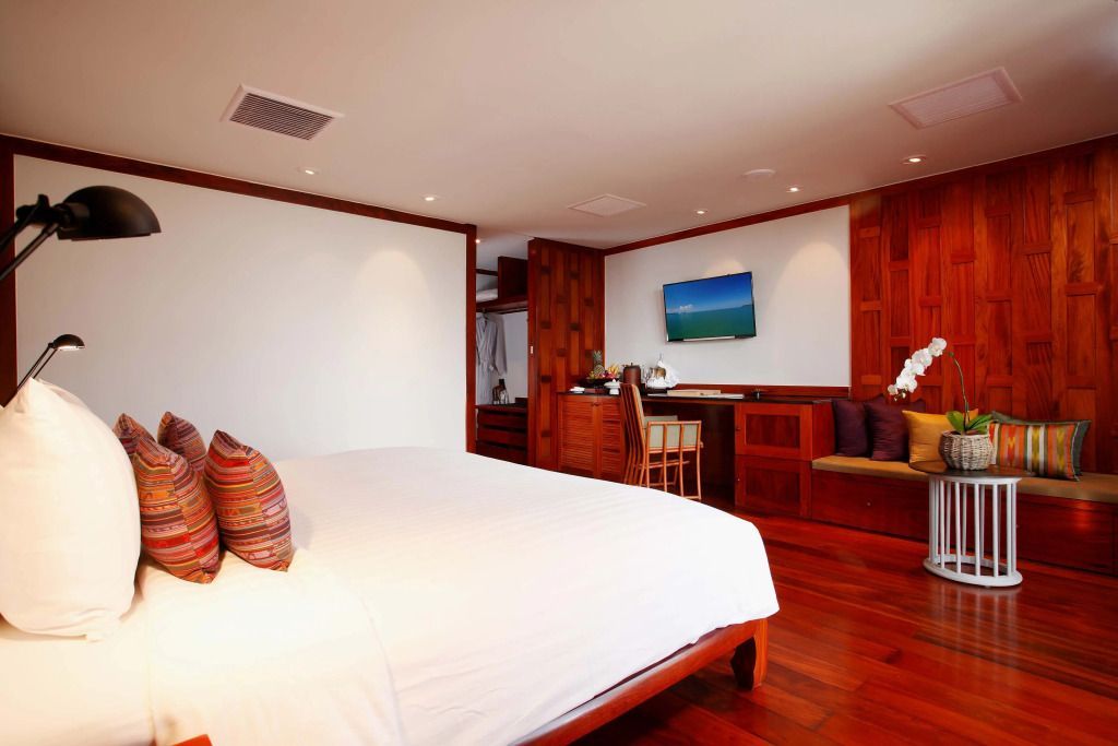 Elegantes Schlafzimmer mit weißem Bett und Holzakzenten in der Amanpuri Garden Villa