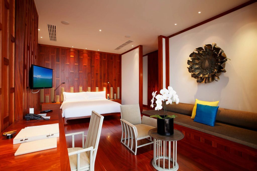 Luxuriöses Schlafzimmer mit Holzwänden, Kunstwerk, Orchidee und moderner Einrichtung