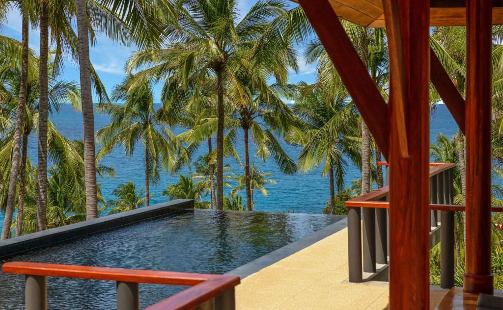 Infinity-Pool mit Palmen und Meer im Hintergrund