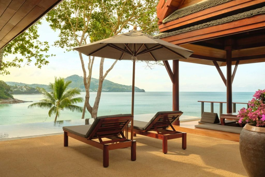 Terrasse des Amanpuri mit Liegen und Blick auf das Meer und Palmen
