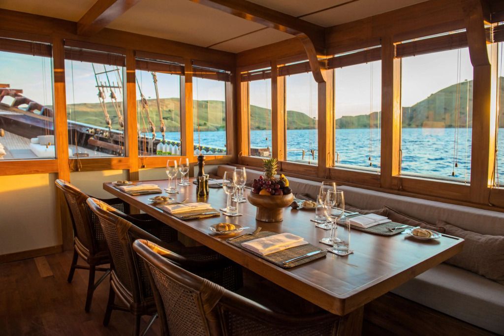 Essbereich auf einem Schiff mit Fenstern zum Meer und elegant gedecktem Tisch