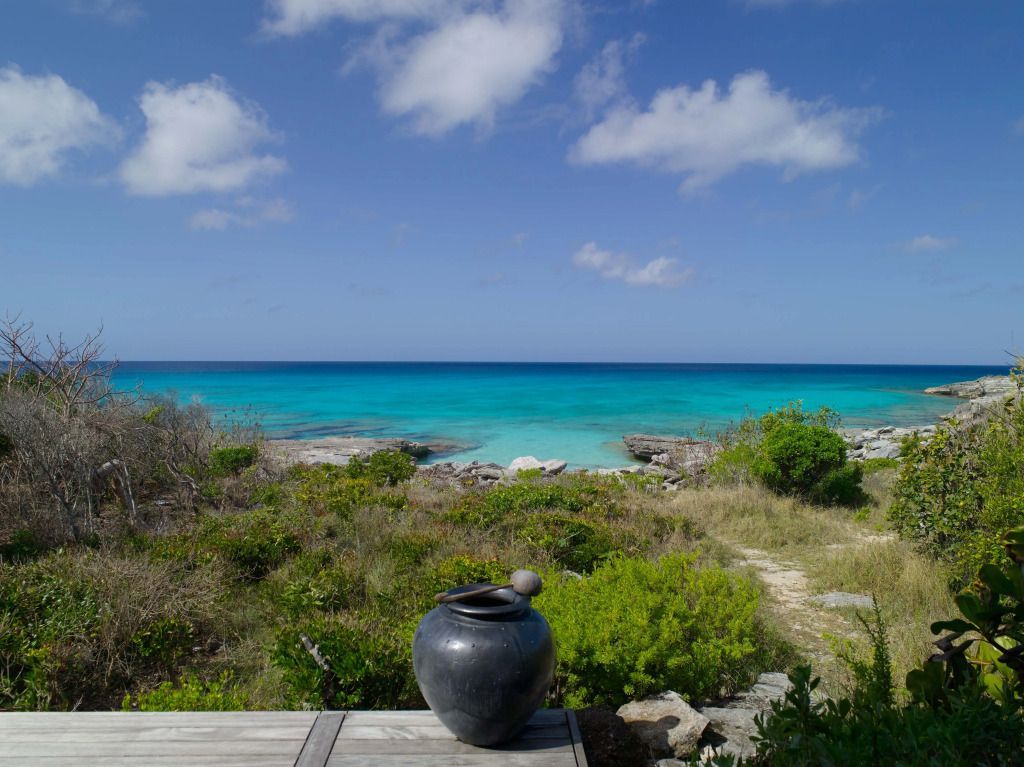 Blick auf das Meer vom Garten des Amanyara Hotels mit azurblauem Wasser und Himmel.