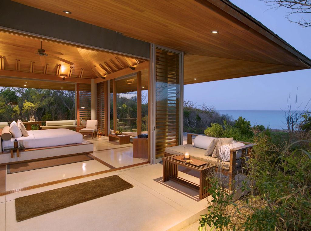 Modernes Zimmer im Amanyara Hotel mit offener Glasfront zum Meer hin.