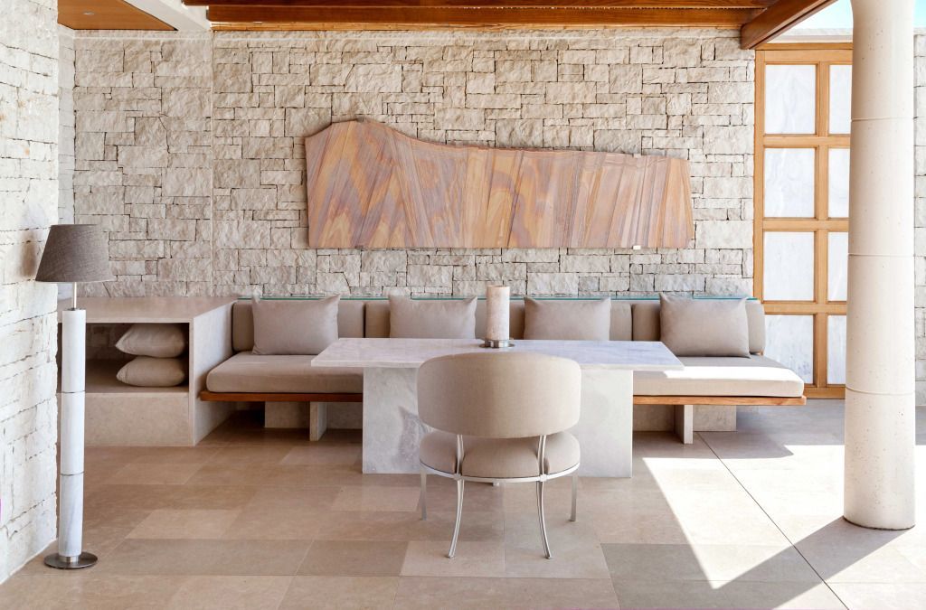 Moderne Sitzmöglichkeit mit Kunstwerk an Steinwand im stilvollen Hotelambiente