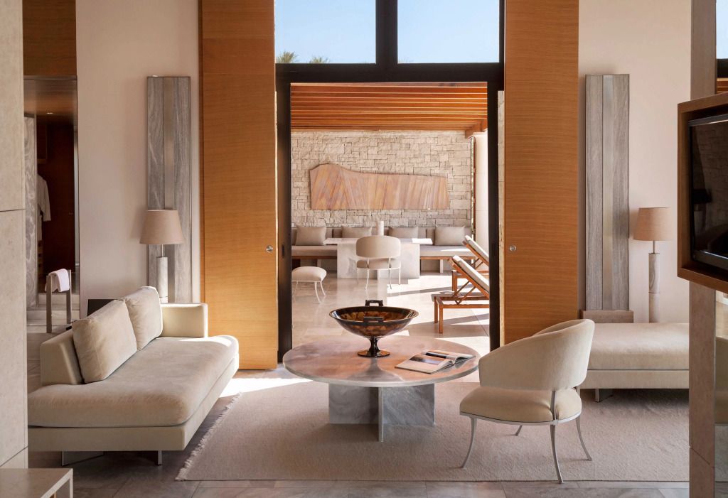 Elegant eingerichtetes Wohnzimmer mit Zugang zu einer Terrasse mit Kunstwerk an der Wand