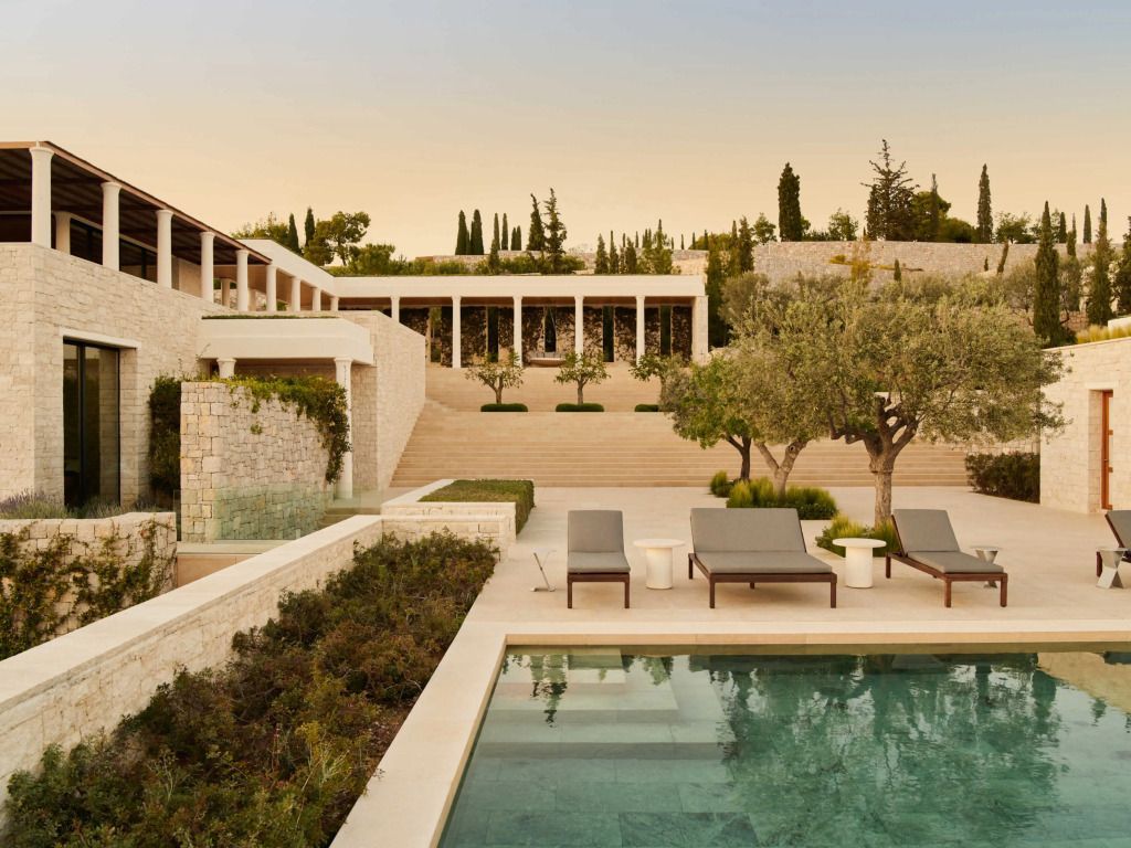Elegante Hotelterrasse mit Pool und Garten bei Abenddämmerung