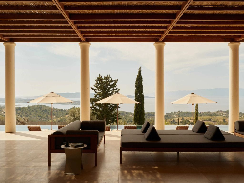 Überdachte Lounge mit Blick auf das Meer und Sonnenschirmen im Hintergrund