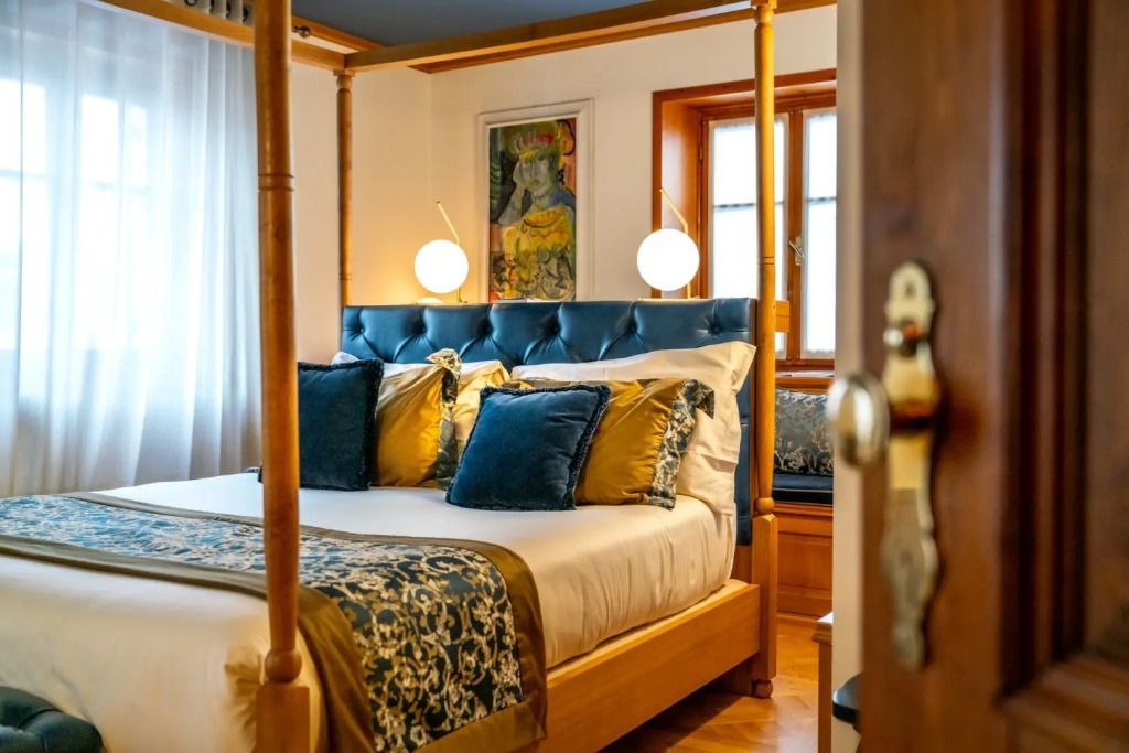 Gemütliches Doppelzimmer mit blauen und goldenen Akzenten und modernen Leuchten