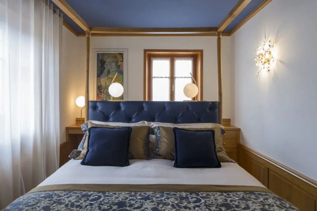 Modernes Doppelzimmer mit blauer Bettwäsche und stilvollen Dekorationselementen