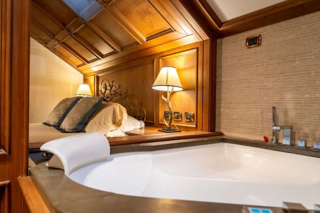 Großer Jacuzzi im Hotelzimmer mit Holzvertäfelung im Hotel Ambra Cortina