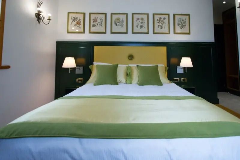 Luxuriöses Doppelbett mit grünen Details und eleganter Wanddekoration