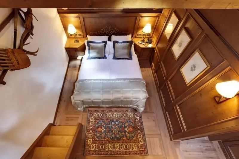 Gemütliches Doppelzimmer mit Holzvertäfelung und Teppich, Blick von oben