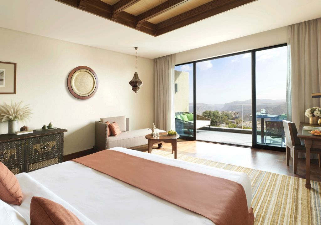 Helles Hotelzimmer mit großem Fenster und Blick auf die Berge