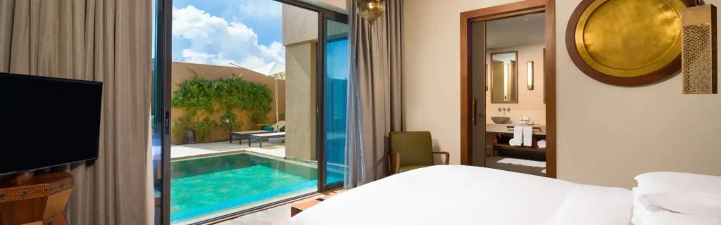 Helles Schlafzimmer mit Blick auf den Pool in der Garden Doppel Pool Villa