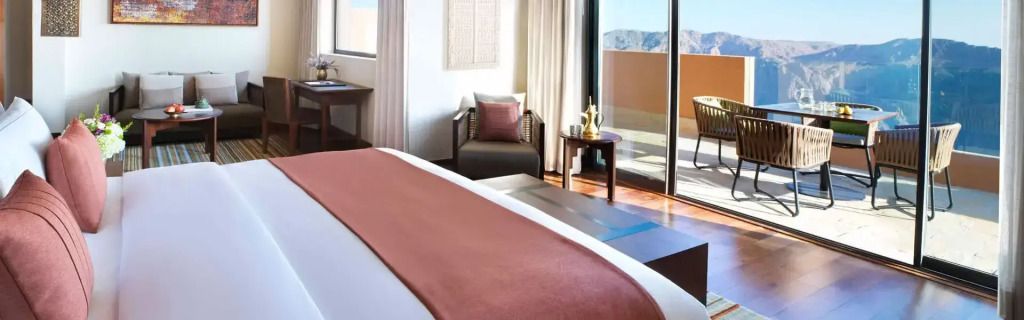 Elegantes Schlafzimmer mit Balkon und Bergblick im Anantara Al Jabal Al Akhdar Resort
