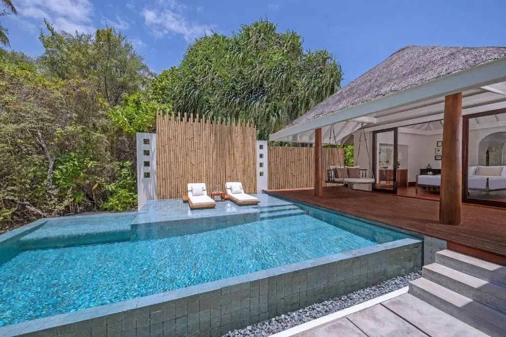 Infinity-Pool mit Liegen und tropischer Umgebung