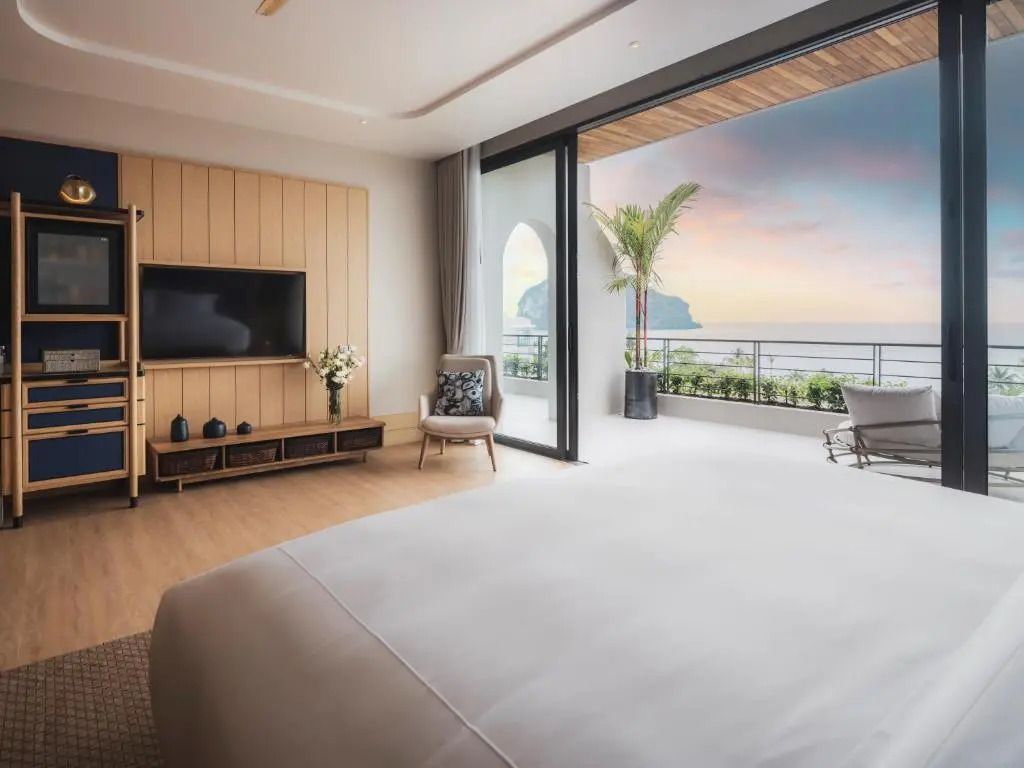Suite mit Balkonaussicht auf Meer und Palmen bei Sonnenuntergang
