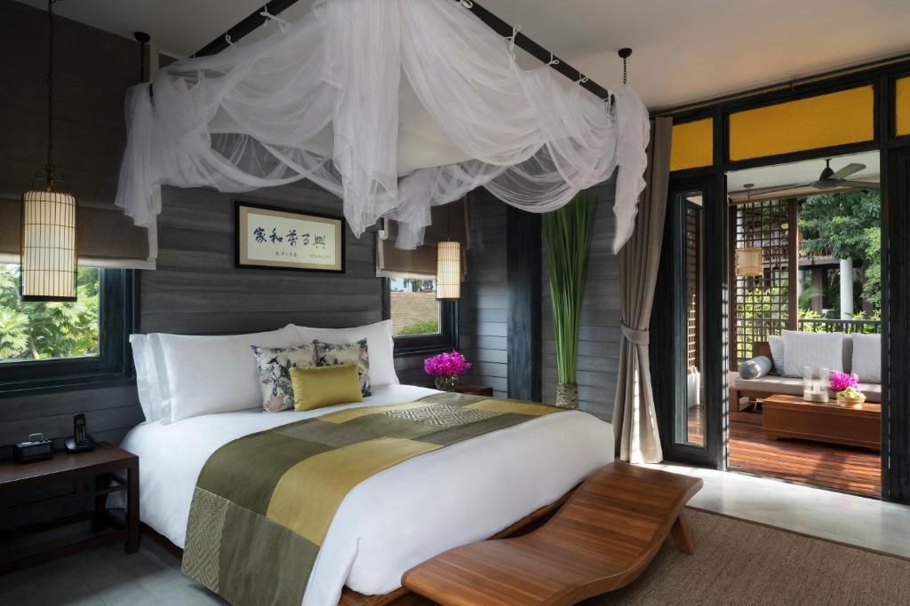 Deluxe Zimmer mit Doppelbett und Baldachin, modern eingerichtet.