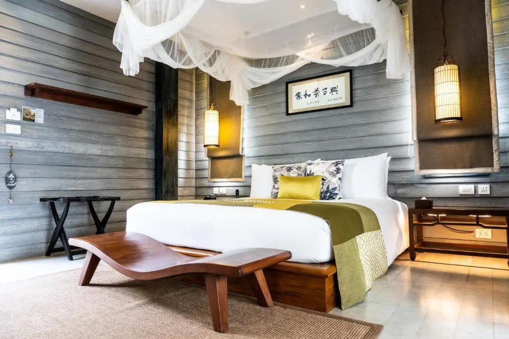 Luxuriöses Doppelbett mit Baldachin in einer eleganten Suite mit Holzakzenten
