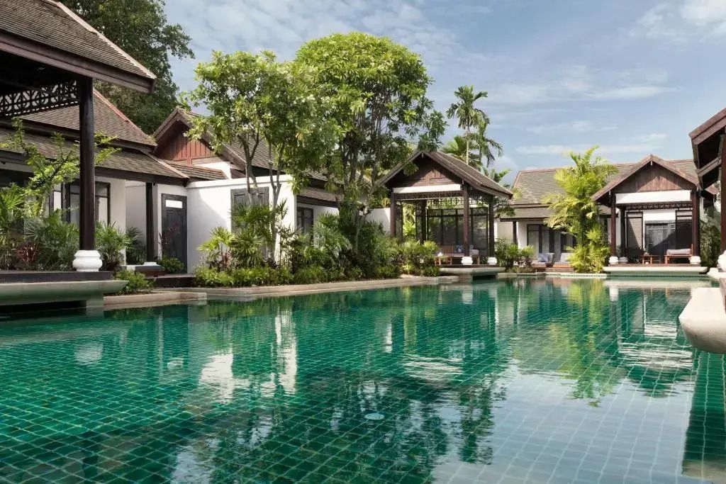 Einladender Pool mit umgebendem tropischen Garten und Villen im Hintergrund