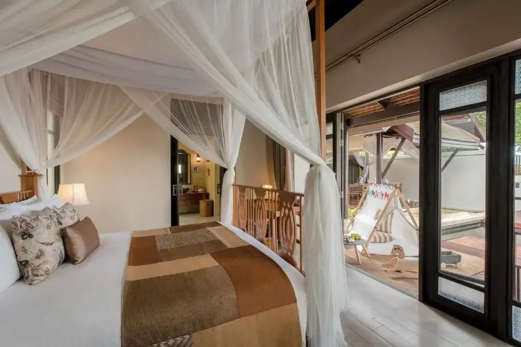 Elegantes Schlafzimmer mit Himmelbett und Balkonzugang in einer Villa.