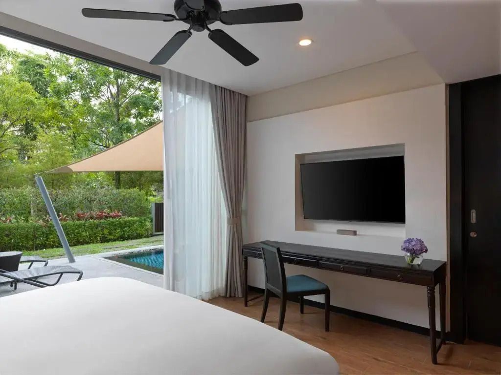 Helles Zimmer mit Poolblick durch große Fensterfront und elegantem Schreibtisch