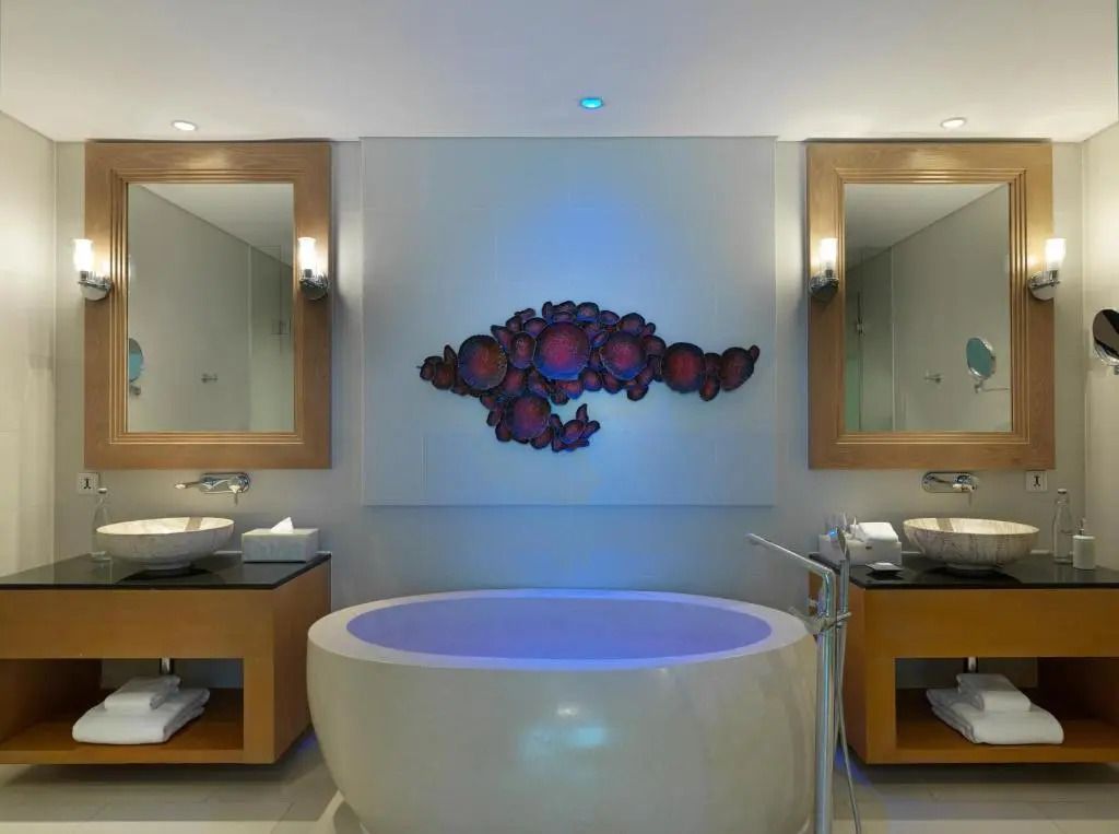 Luxuriöses Badezimmer mit freistehender Badewanne und dekorativer Wandkunst