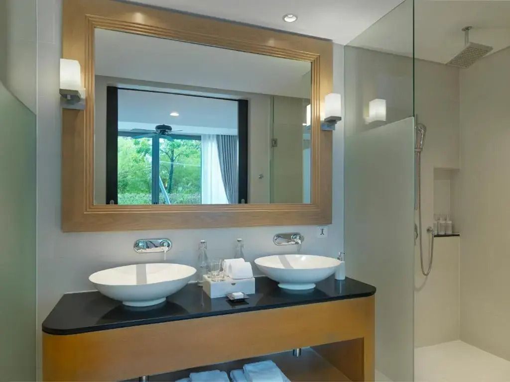 Elegantes Doppelwaschbecken im modernen Badezimmer mit großem Spiegel und Glasduschwand
