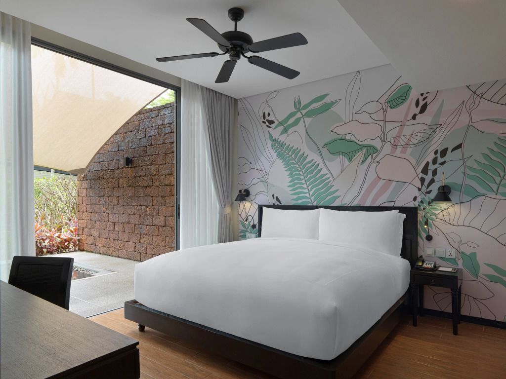 Helles Schlafzimmer mit Doppelbett und floraler Wanddekoration