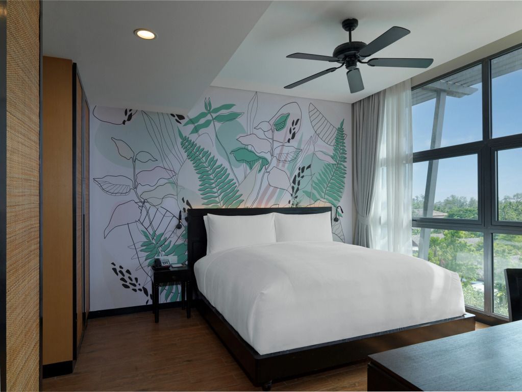 Moderne Suite mit großem Fenster und elegantem Doppelbett