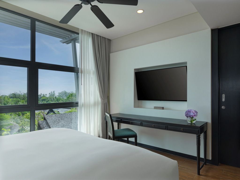 Suite mit Schreibtisch, großem Fenster und Blick auf tropische Umgebung
