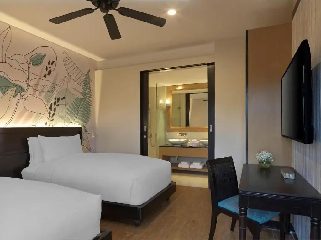 Zwei Betten in einem modernen Zimmer mit stilvoller Dekoration und Badzugang