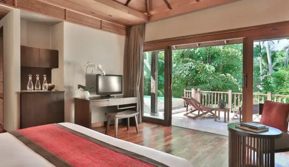 Suite mit Doppelbett und Zugang zur Terrasse mit Blick auf einen privaten Pool