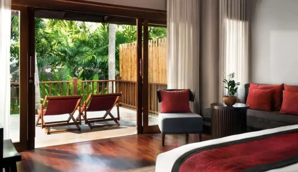 Terrasse mit Liegestühlen und Blick auf tropische Vegetation in der Suite