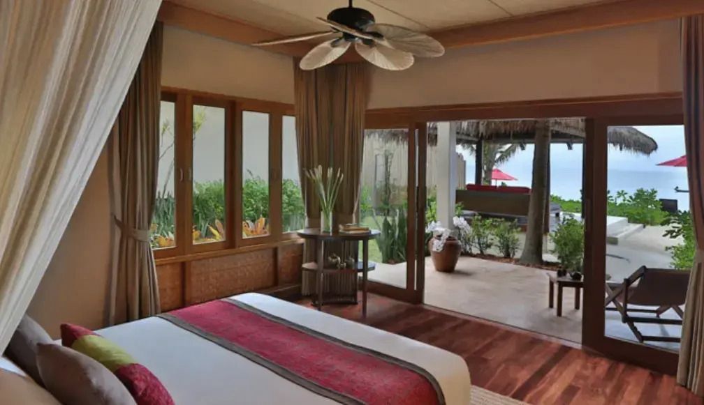 Geräumiges Schlafzimmer mit Blick auf die Terrasse und Garten im Hintergrund