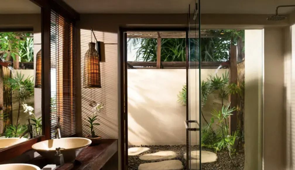 Modernes Badezimmer mit Glaswand und Zugang zu kleinem Gartenbereich