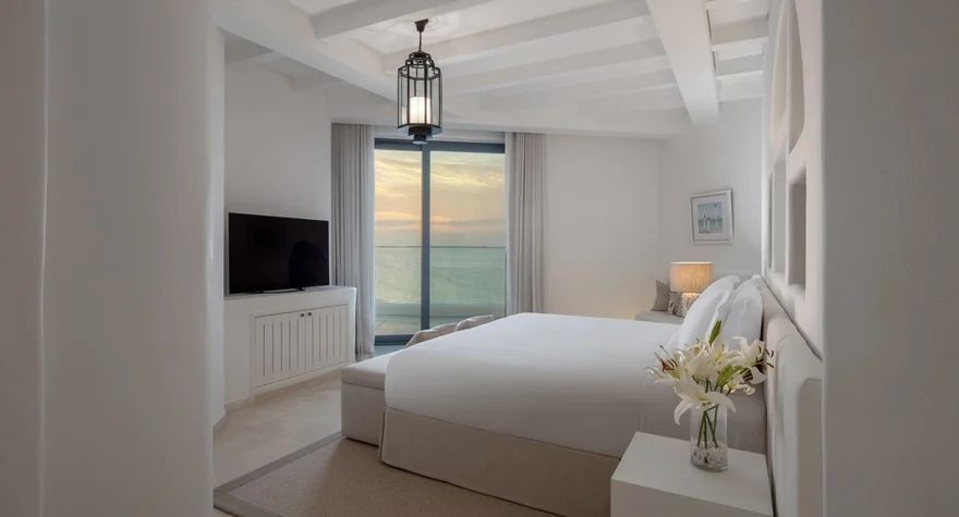 Helles Schlafzimmer mit Doppelbett und Meerblick in Oia Suite des Hotels.