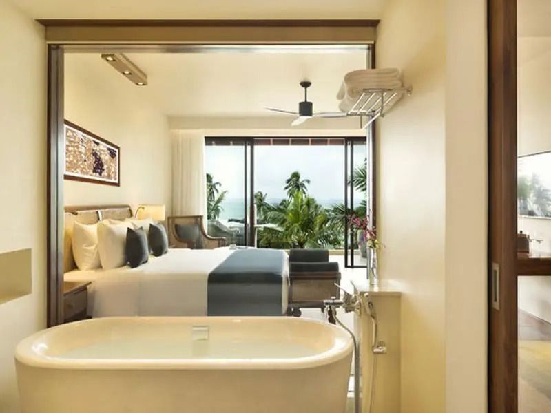 Zimmeransicht mit freistehender Badewanne und Meerblick durch große Fenster