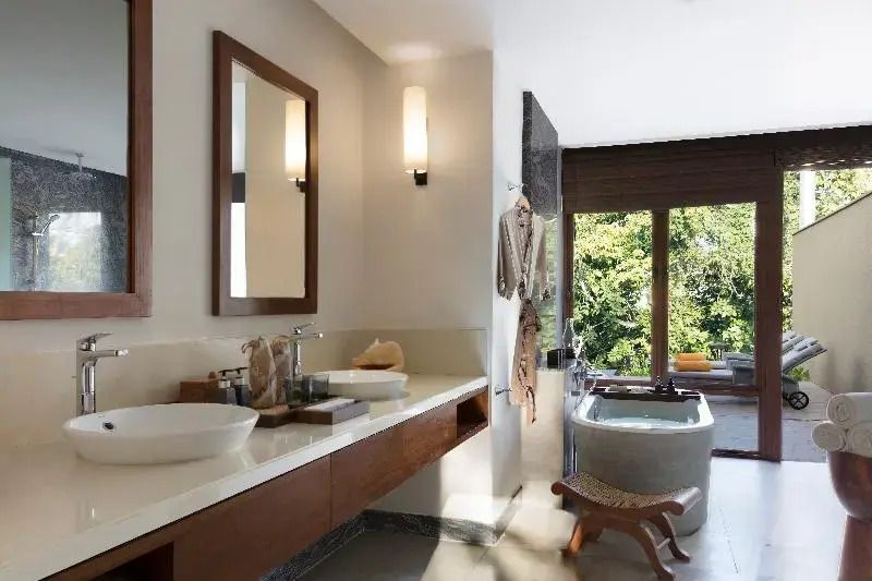 Stilvolles Badezimmer mit Badewanne und Aussicht ins Grüne